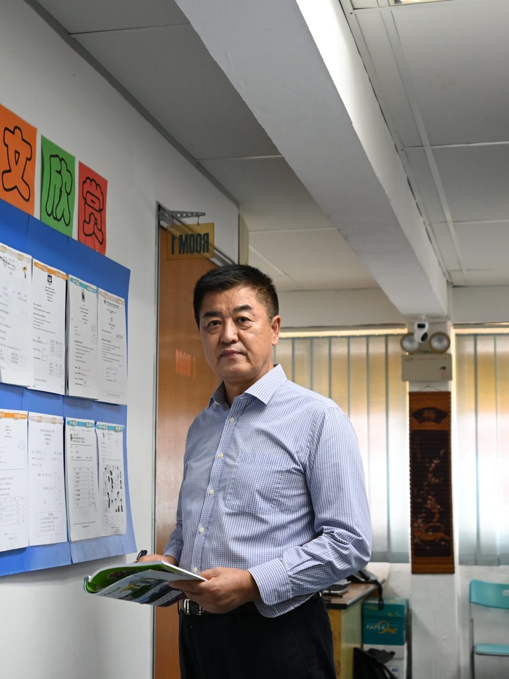 Portrait of a tutor beside the class timetable